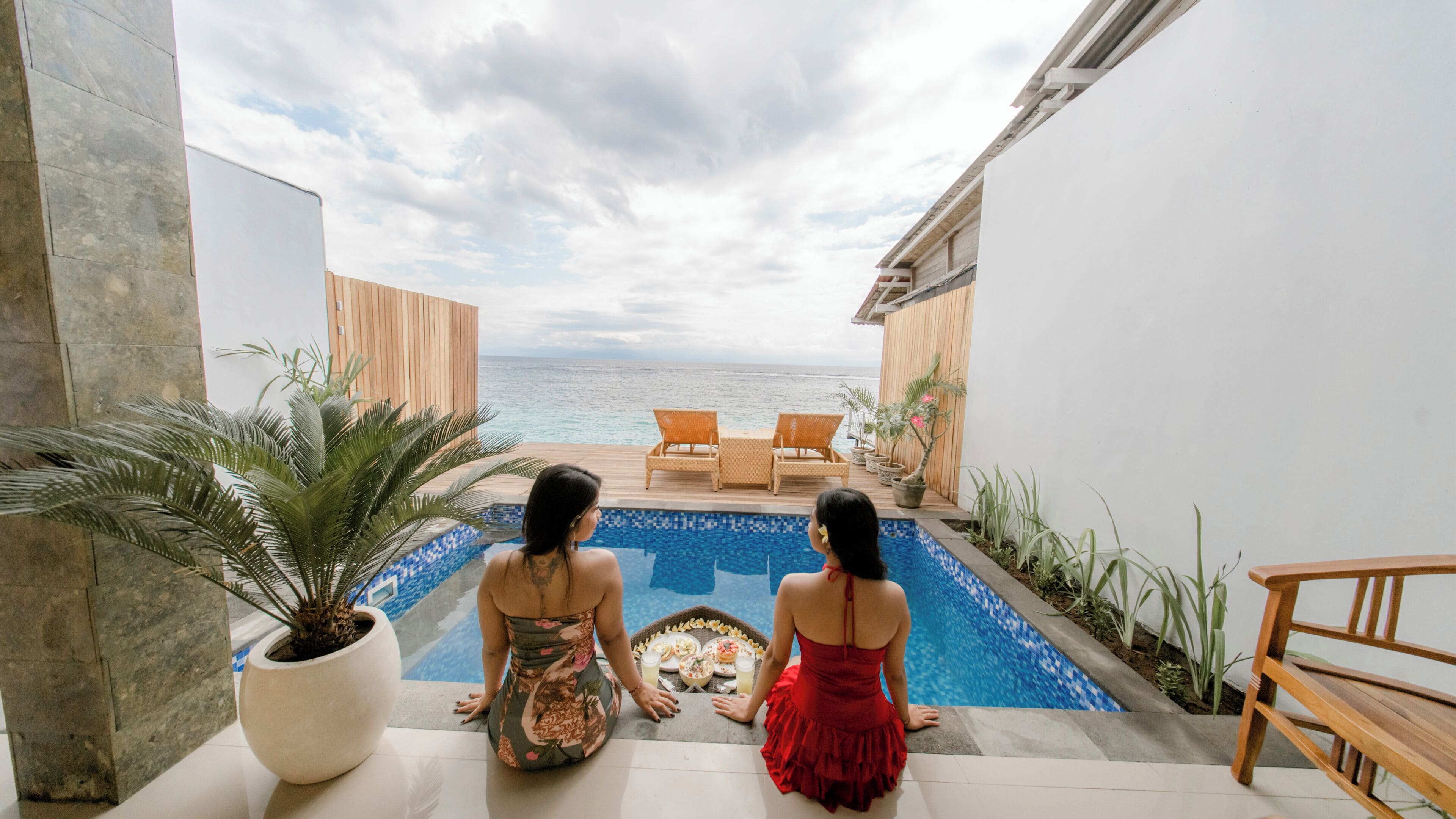 Une vue sur la piscine, avec deux chaises longues et une table à manger.