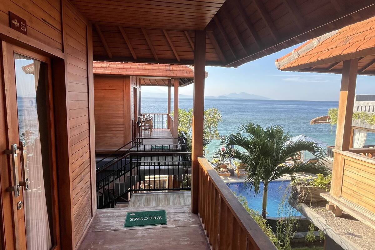 Un balcon en bois avec vue sur la mer.