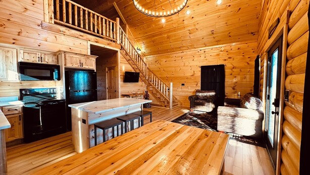 Ein Blockhaus-Interieur mit Küche, Essbereich und Wohnzimmer.