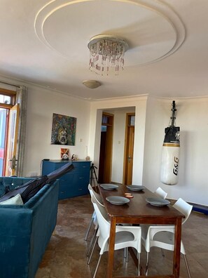 Enjoy meals in this dining area with a table for four, surrounded by comfortable seating and a stylish light fixture.