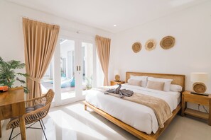 Un dormitorio con una cama de madera, una mesita de noche de madera, una silla de mimbre y una mesa de comedor.