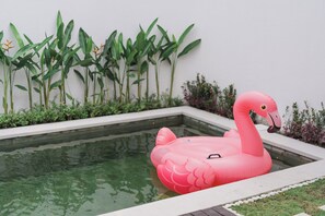 Une piscine avec un flotteur en forme de flamant rose.