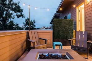 Un espacio al aire libre con sillas, una mesa y un brasero.