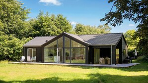 A modern house with large glass windows, a covered porch, and a well-maintained lawn. - 5 bedroom nice home in Græsted (Græsted)