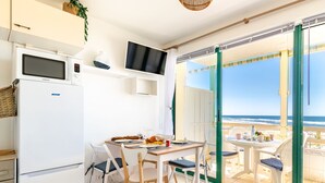 Une cuisine moderne équipée d’un réfrigérateur Samsung, d’une table à manger avec des chaises et d’un téléviseur fixé au-dessus du comptoir.