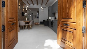 A spacious living area with wooden doors, a dining table, and a kitchen in the background. - My Loft 4 You Patraix Style (Valencia)