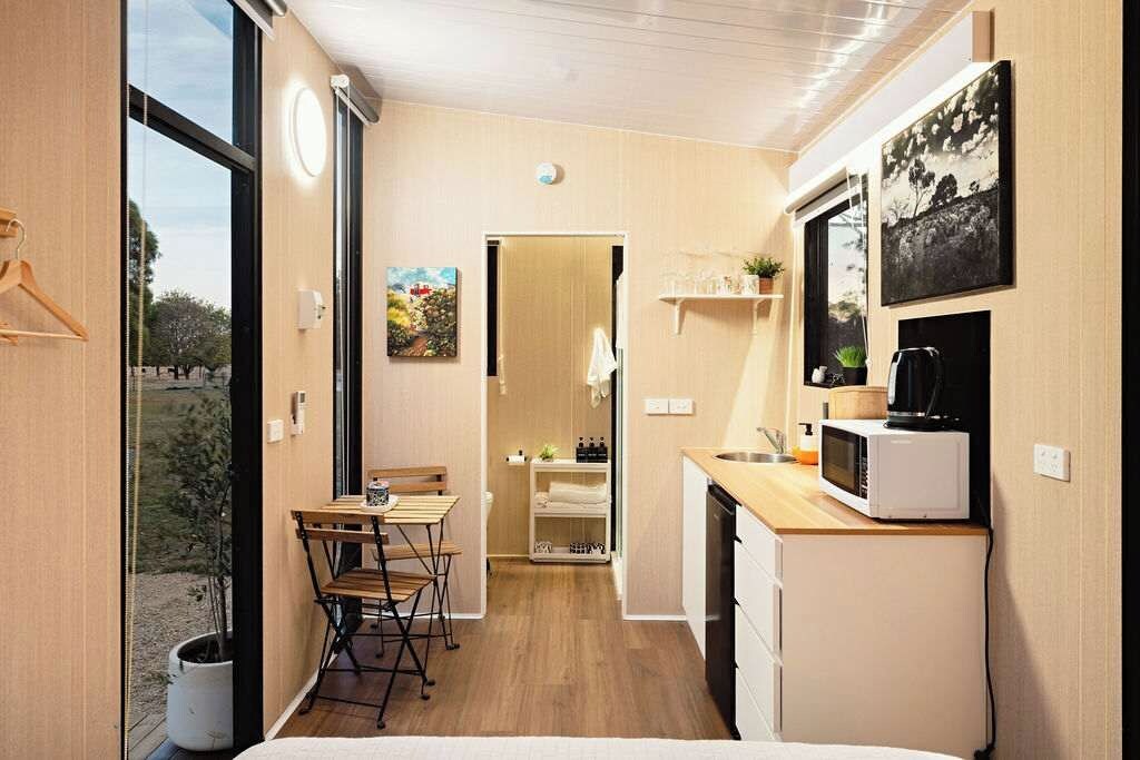 Une cuisine compacte comprenant un coin repas, un four à micro-ondes et un petit évier.