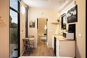 A compact kitchen with a dining area, a microwave, and a small sink. - Ballarat Bliss by Tiny Away (Cardigan)
