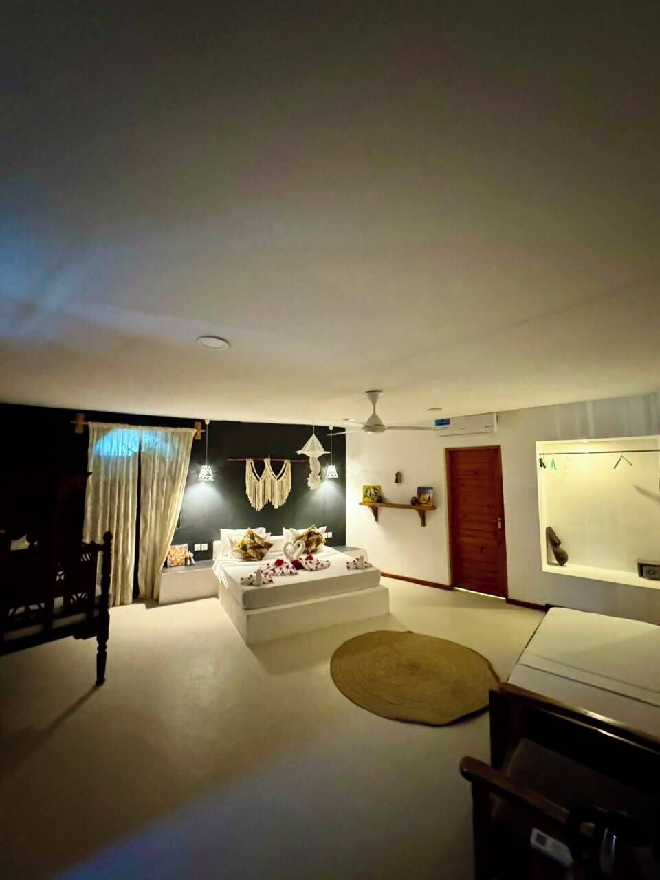 Una sala de estar con sofá, mesa de centro, televisor y ventilador de techo.