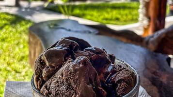Un vaso de helado de chocolate con una playa y palmeras al fondo.