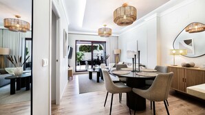 Een moderne eetruimte met een ronde tafel, stoelen en hanglampen.