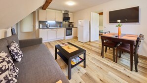 Un appartement moderne comprenant un salon, une cuisine et un coin repas.
