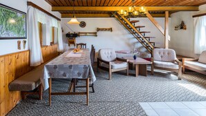 A cozy dining area with a wooden table, chairs, and a staircase leading to an upper level. - Vacation home Hoja by Interhome (Vítkovice)