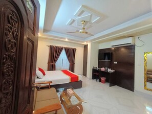 A hotel room with a bed, a desk, a TV, and a wardrobe. - Hotel White Stone (Dhaka)