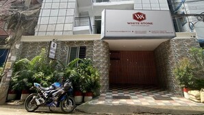 Un edificio de varios pisos con un letrero llamativo que dice "WHITE STONE".