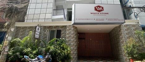 Un edificio de varios pisos con un letrero llamativo que dice "WHITE STONE".