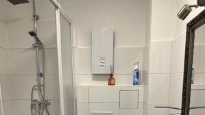 Une salle de bain moderne équipée d’une douche, de toilettes et d’un lavabo.