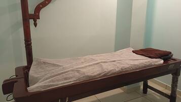 Cozy single-occupancy room with a comfortable bed, simple design, and a small chair.