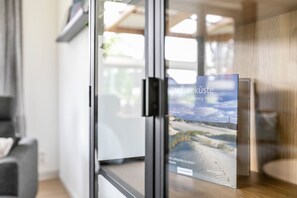 Ein modernes Interieur mit einer Glastür, die zu einem Raum führt.