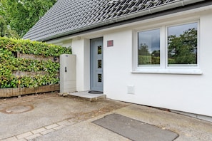 Un bâtiment blanc avec une porte grise, une fenêtre et une enseigne portant le numéro « 41 ».