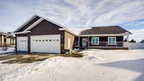Ein zweistöckiges Haus mit Garage und überdachter Veranda.