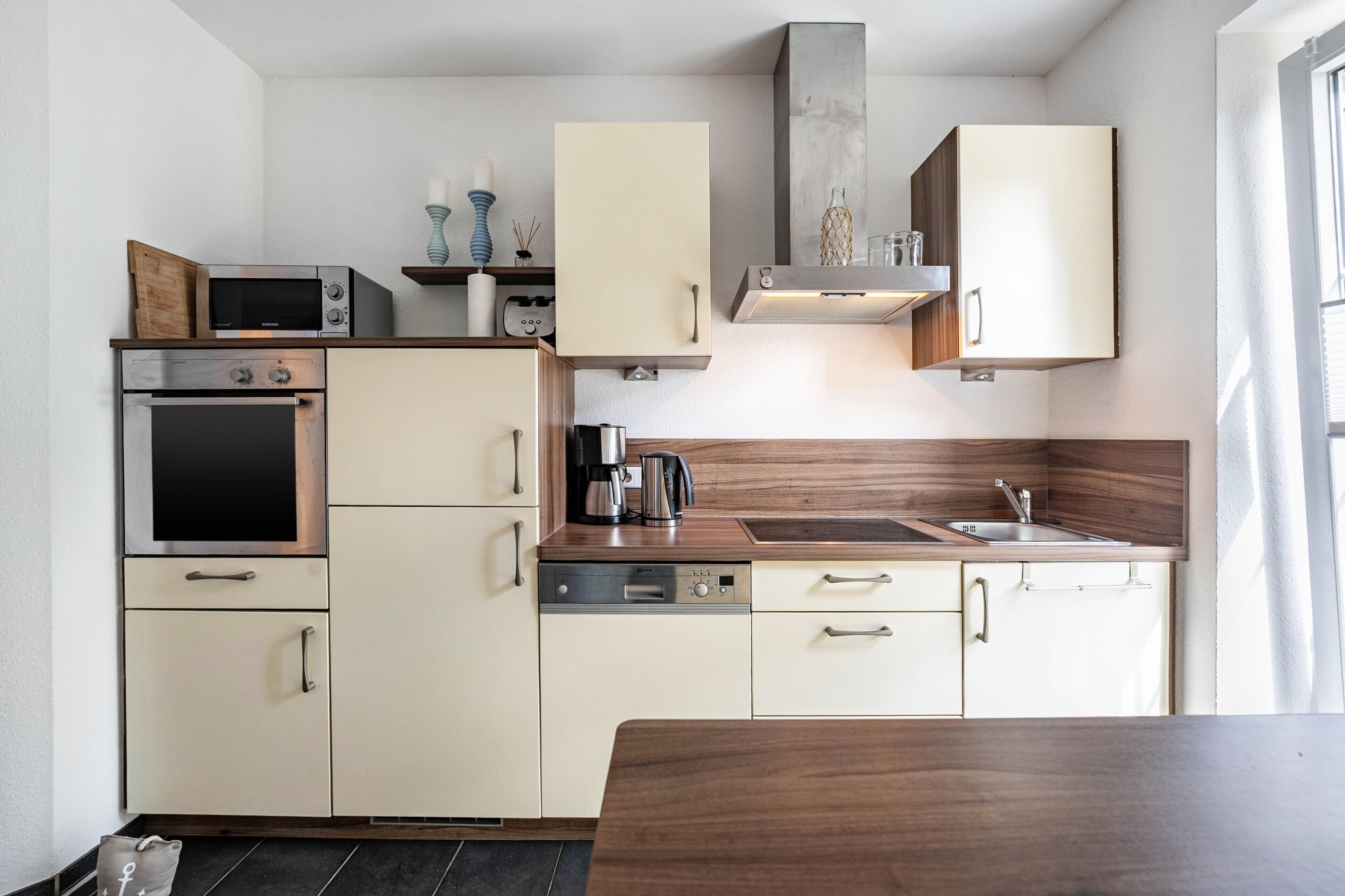 Eine kleine Küche mit Mikrowelle, Backofen, Kaffeemaschine und Spüle.