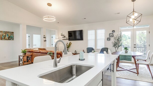A modern kitchen with a large island, white countertops, and a stainless steel sink. - Seasonal Pool, Balcony: Quiet & Cozy Aurora Condo! (Aurora)