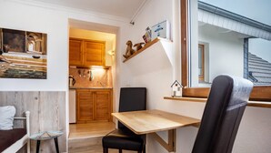 A compact living space with a dining area, a kitchen, and a view of the outside. - Apartment 'Ferienwohnung Relax' with Private Terrace, Private Garden and Wi-Fi (Stralsund)