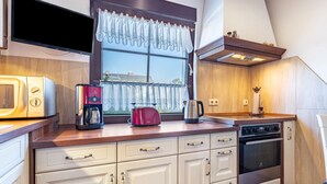 Uma cozinha equipada com micro-ondas, cafeteira, torradeira e forno.