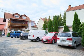 A parking area with several cars and a building with a sloped roof.