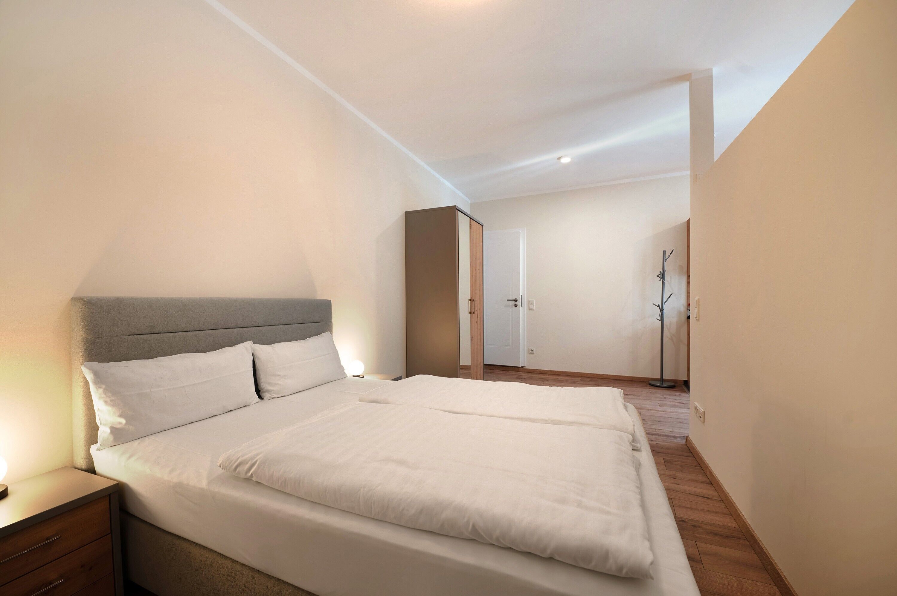 Et soveværelse med seng, natbord og garderobe.