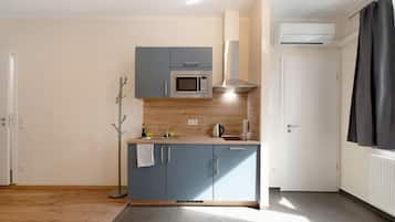 Une cuisine compacte équipée d’un four à micro-ondes, d’une cuisinière et d’un four encastré.