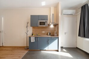 A compact kitchen with a microwave, stove, and a built-in oven.