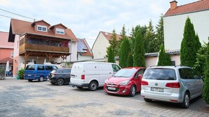 Ein Parkplatz mit mehreren Autos und einem Gebäude mit Schrägdach.