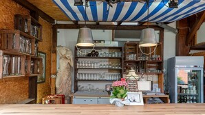 Eine Bar mit Holzböden, einer Statue und einem mit Flaschen gefüllten Kühlschrank.