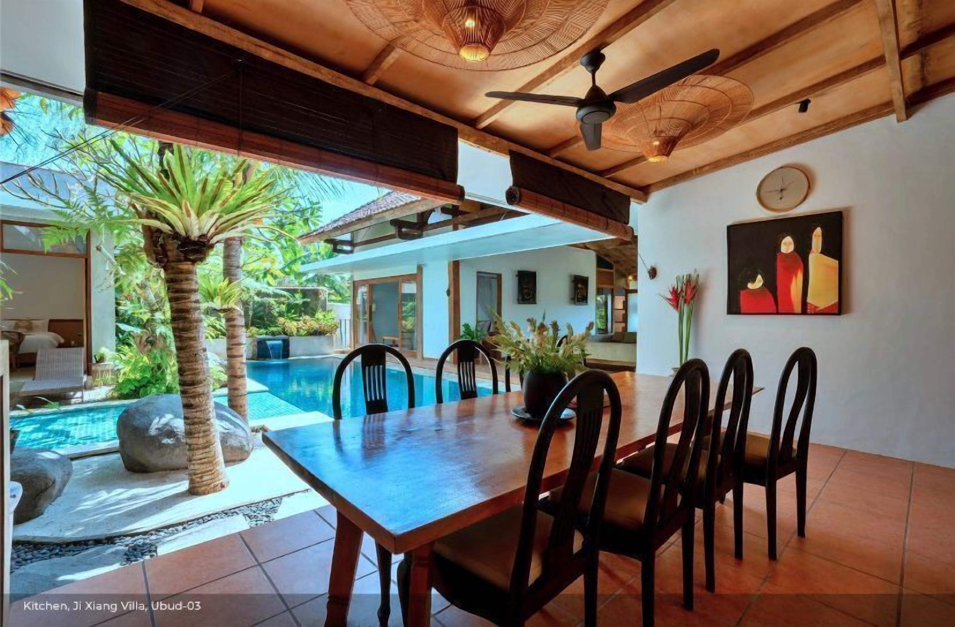 A kitchen with a dining area, a pool, and a view of the outdoors.