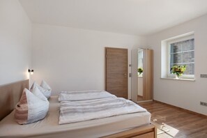 Et soveværelse med seng, garderobeskab, et vindue med udsigt og et natbord.
