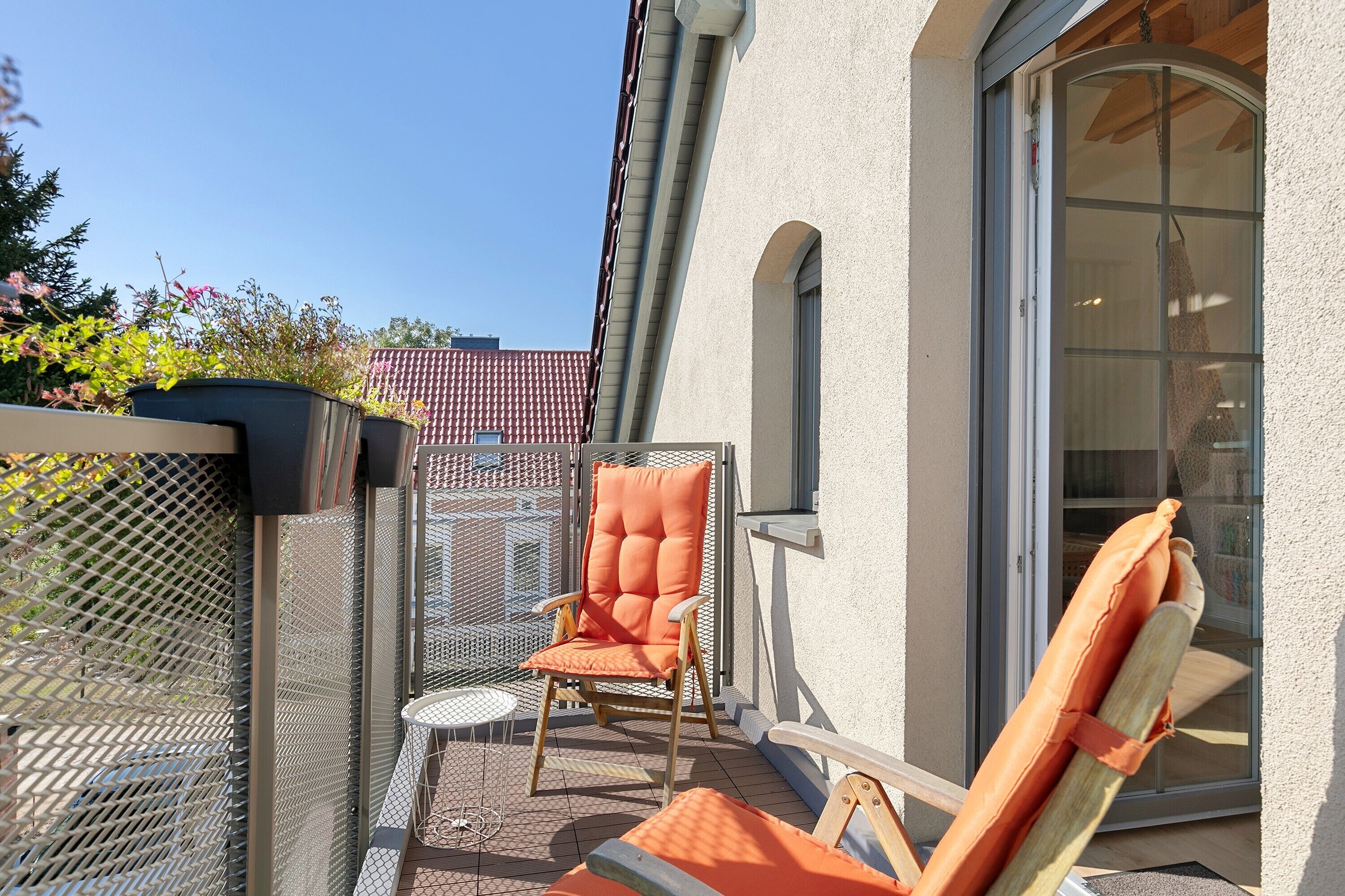 A balcony with a chair, a small table, and a window.
