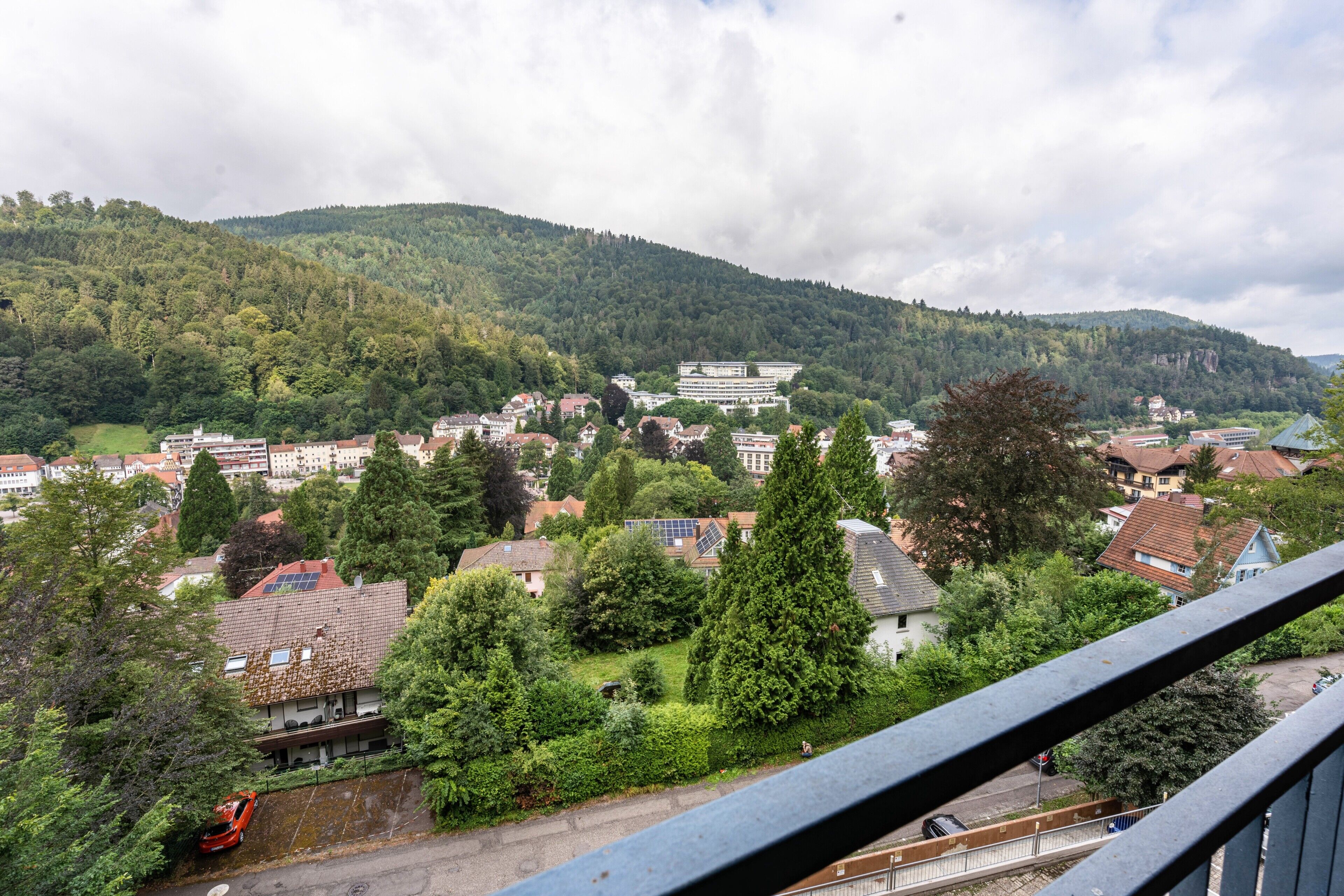 Eine Stadt mit einer Mischung aus Wohn- und Geschäftshäusern, umgeben von Grünflächen und Hügeln.