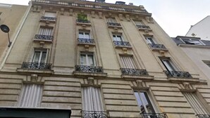 Un edificio de varios pisos con estilo arquitectónico clásico, que presenta balcones ornamentados y ventanas grandes.