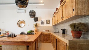 Una cocina moderna con armarios de madera, una isla grande y una lámpara colgante.