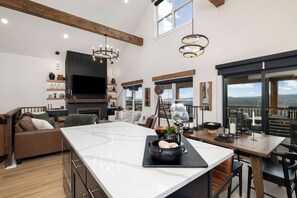 Una cocina amplia con una isla grande, un comedor con vistas y una zona de estar acogedora con chimenea.