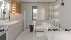 Una cocina moderna con encimera blanca, armarios empotrados y una ventana con persianas.