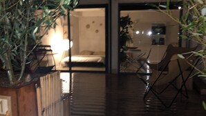 A wooden deck leading to a bedroom with a bed and a small table. - In the heart of the Drôme valley, between Die and Crest,  independent gîte (aurel)