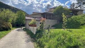 A stone building with a tiled roof, a gravel path, and lush greenery. - In the heart of the Drôme valley, between Die and Crest,  independent gîte (aurel)