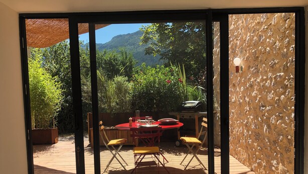 A patio with a table and chairs, a grill, and a view of a mountainous landscape. - In the heart of the Drôme valley, between Die and Crest,  independent gîte (aurel)