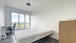 Una camera da letto con un letto singolo, una scrivania e una sedia.