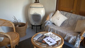 A cozy living area with wicker furniture, a glass-top coffee table with magazines, and a decorative vase.