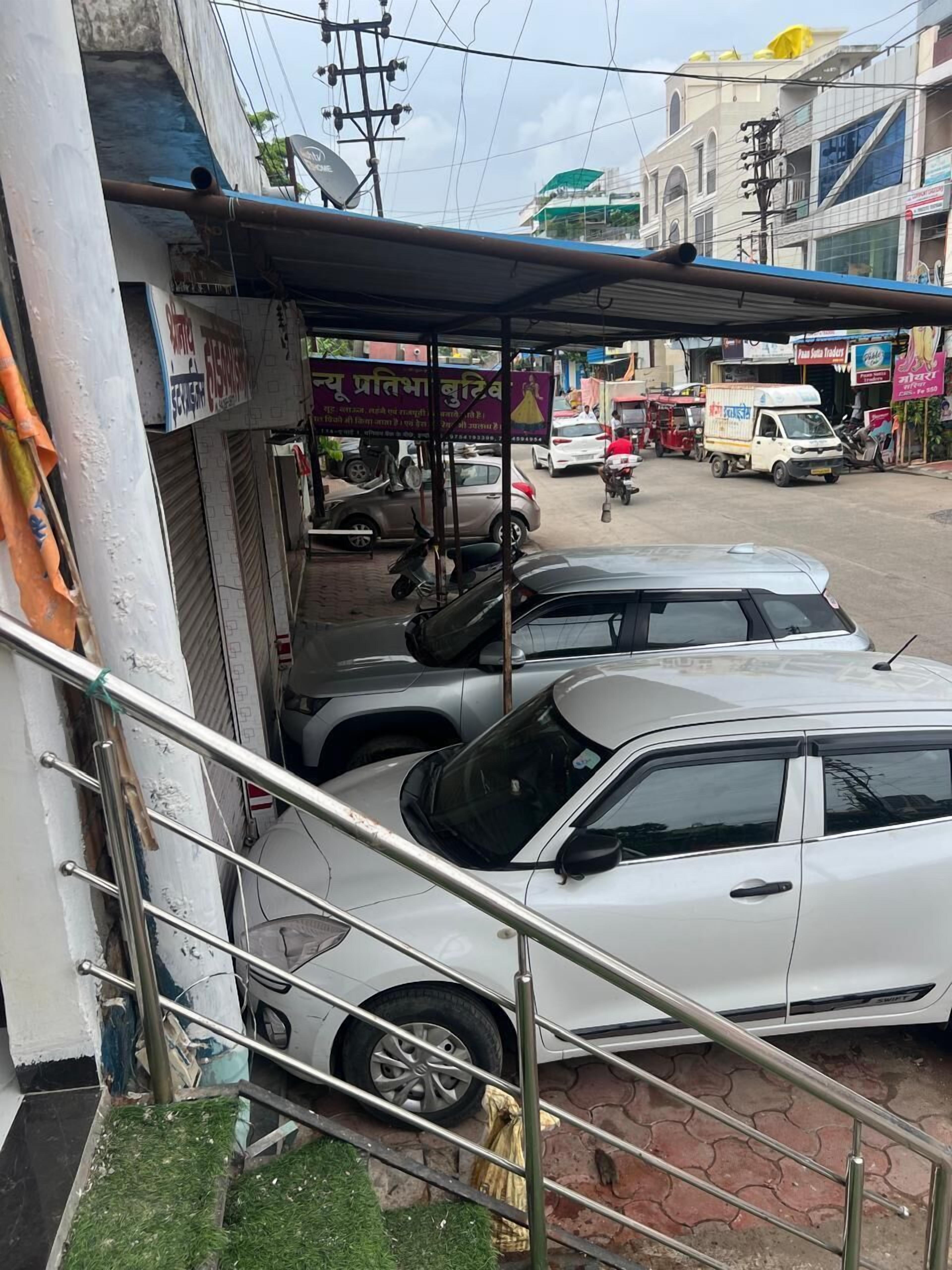 Una vista di strada con auto parcheggiate, un edificio con insegna e un marciapiede.