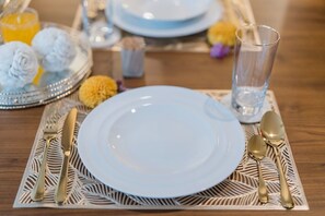 A table set with a white plate, gold cutlery, a clear glass, and a decorative tray with flowers and a glass of orange juice. - Villa Leya Canggu - Ella Villa Bali (Canggu)